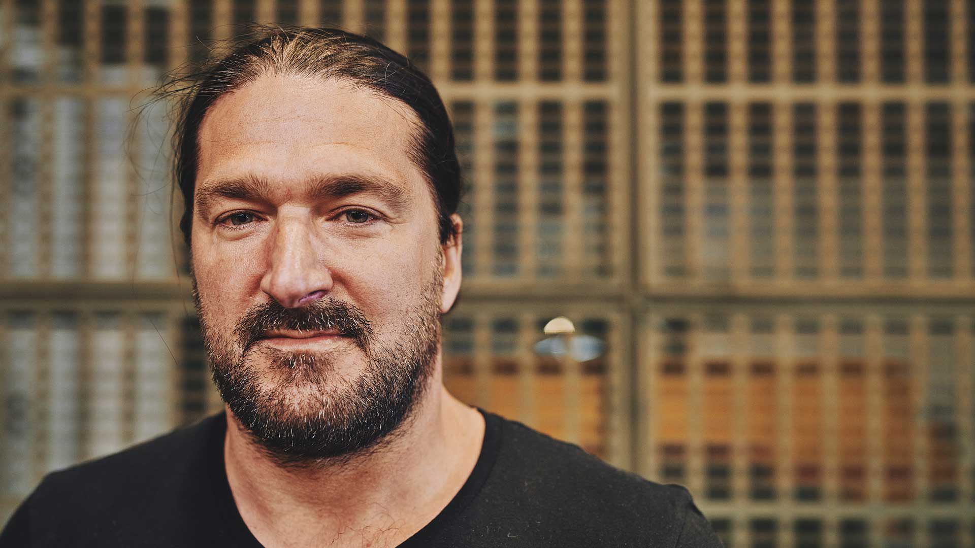 man in a black tshirt looking towards the camera