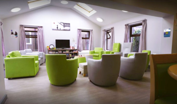 Athena Group Room - a room with white walls, a vaulted ceiling and comfortable green armchairs facing the centre