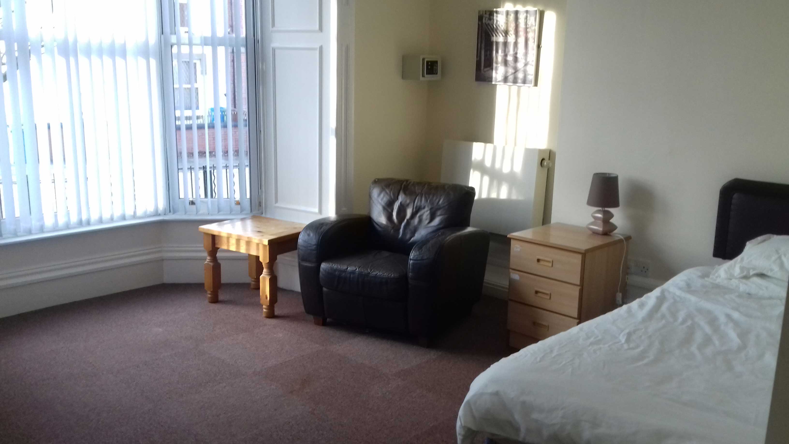 Leigh Bank - Bedroom. Large window, single bed, arm chair and drawers