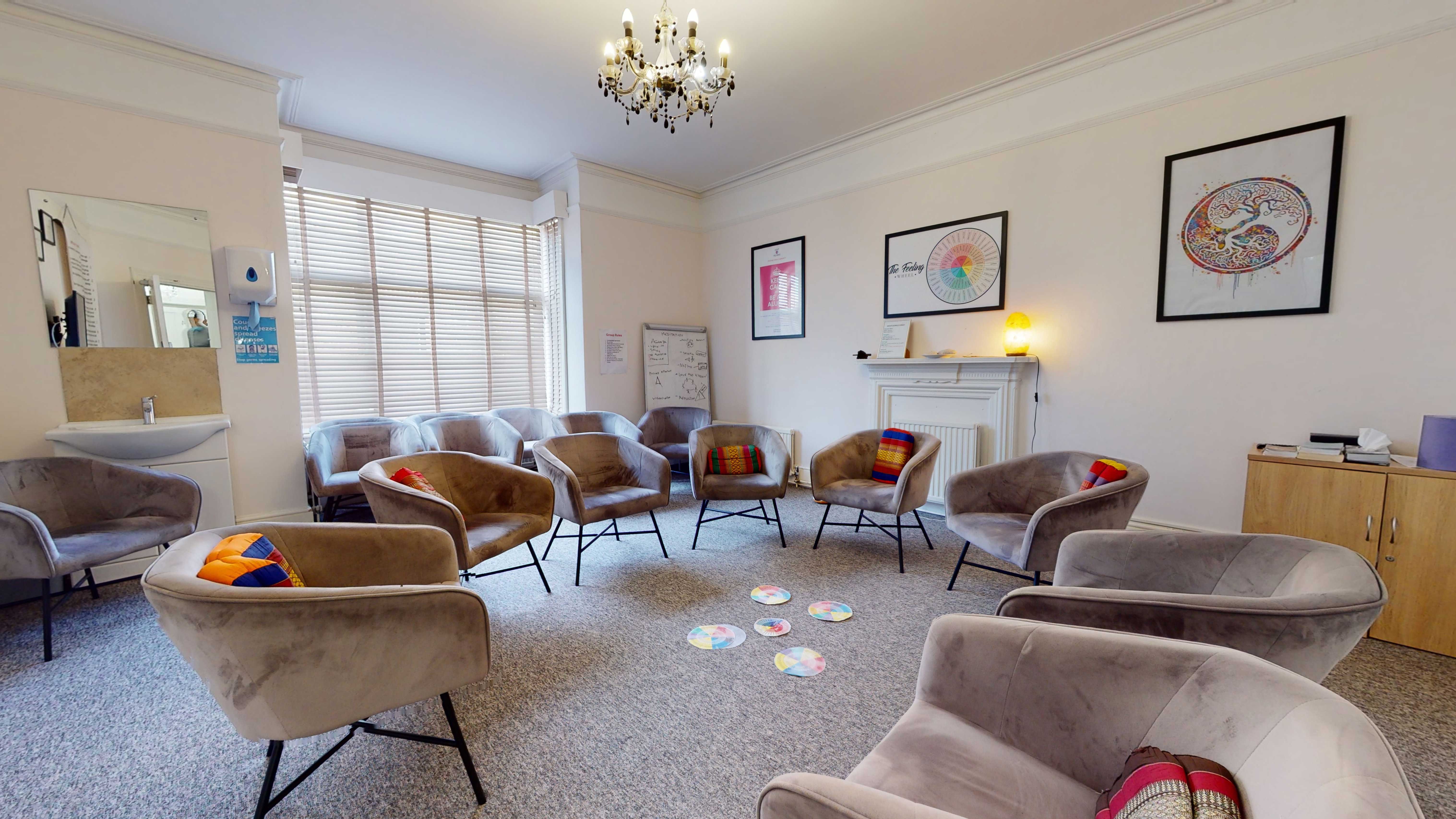 Recovery light house group room - a large room with high ceilings, armcharis and art