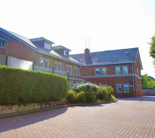 The outside of a building with hedges in front of it.