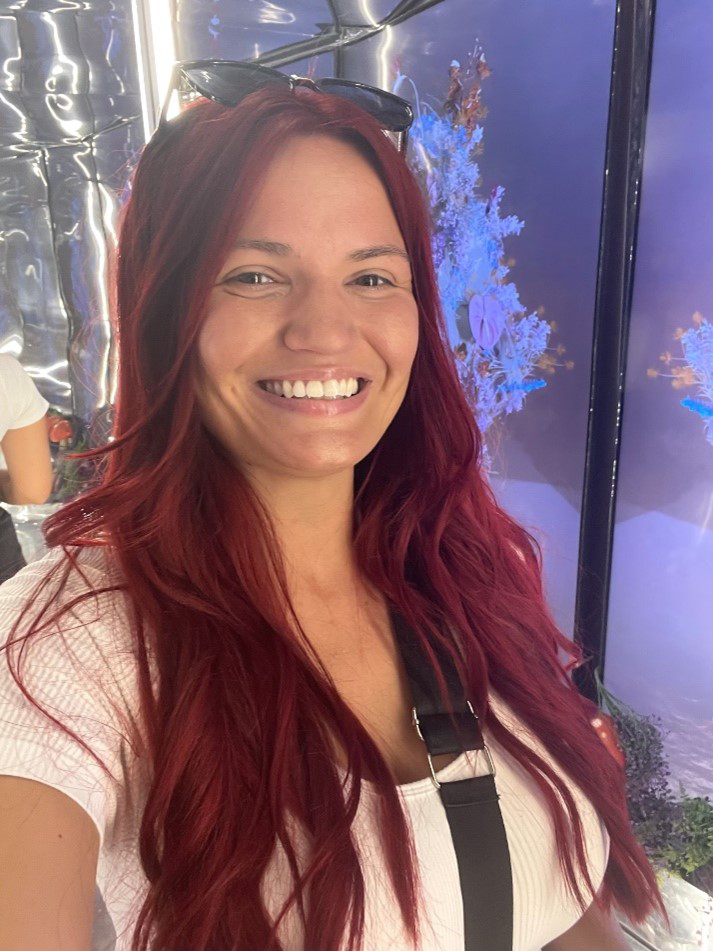 A woman with red hair smiling at the camera