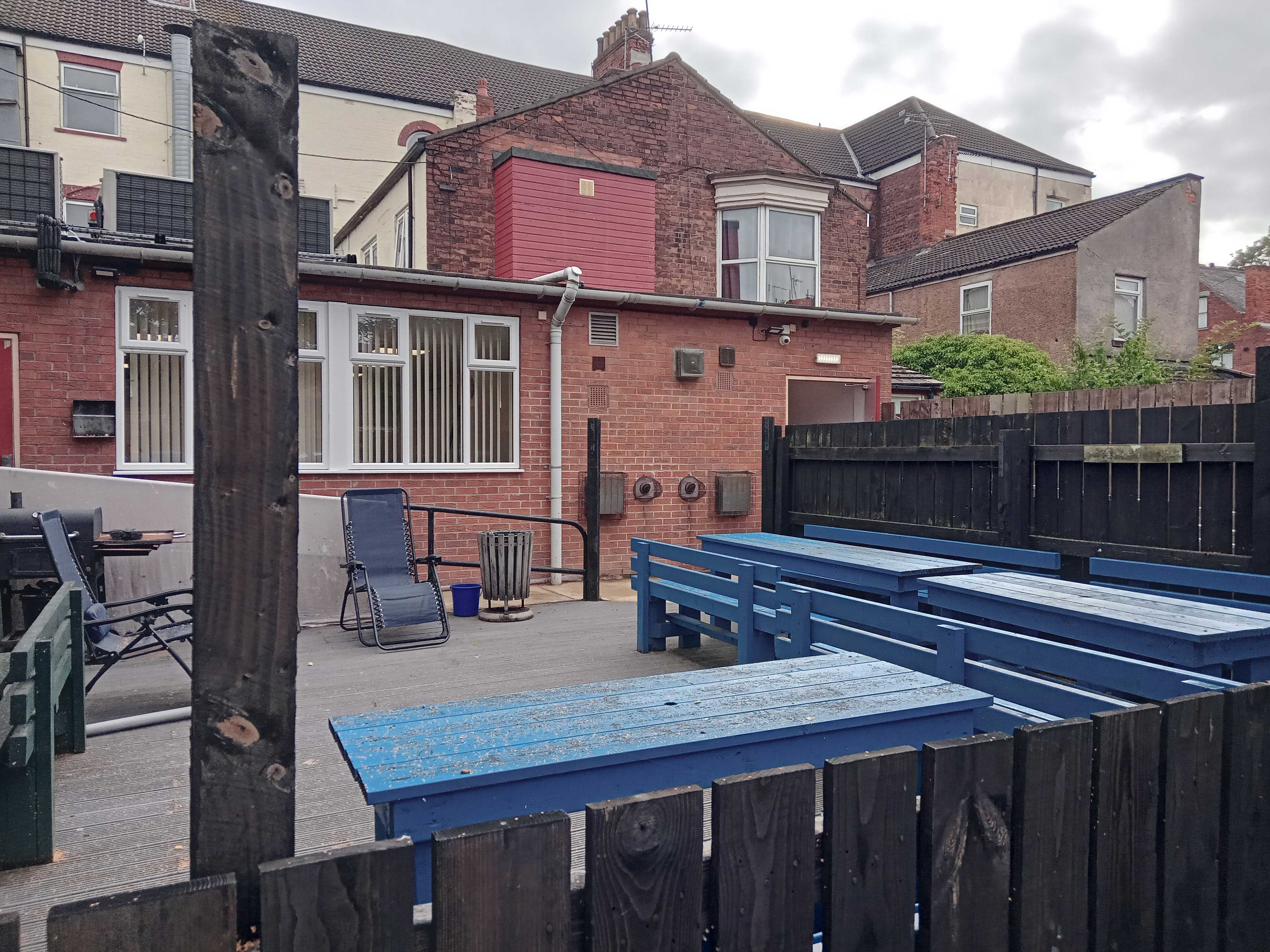 Blue wooden benches in the corner of a garden