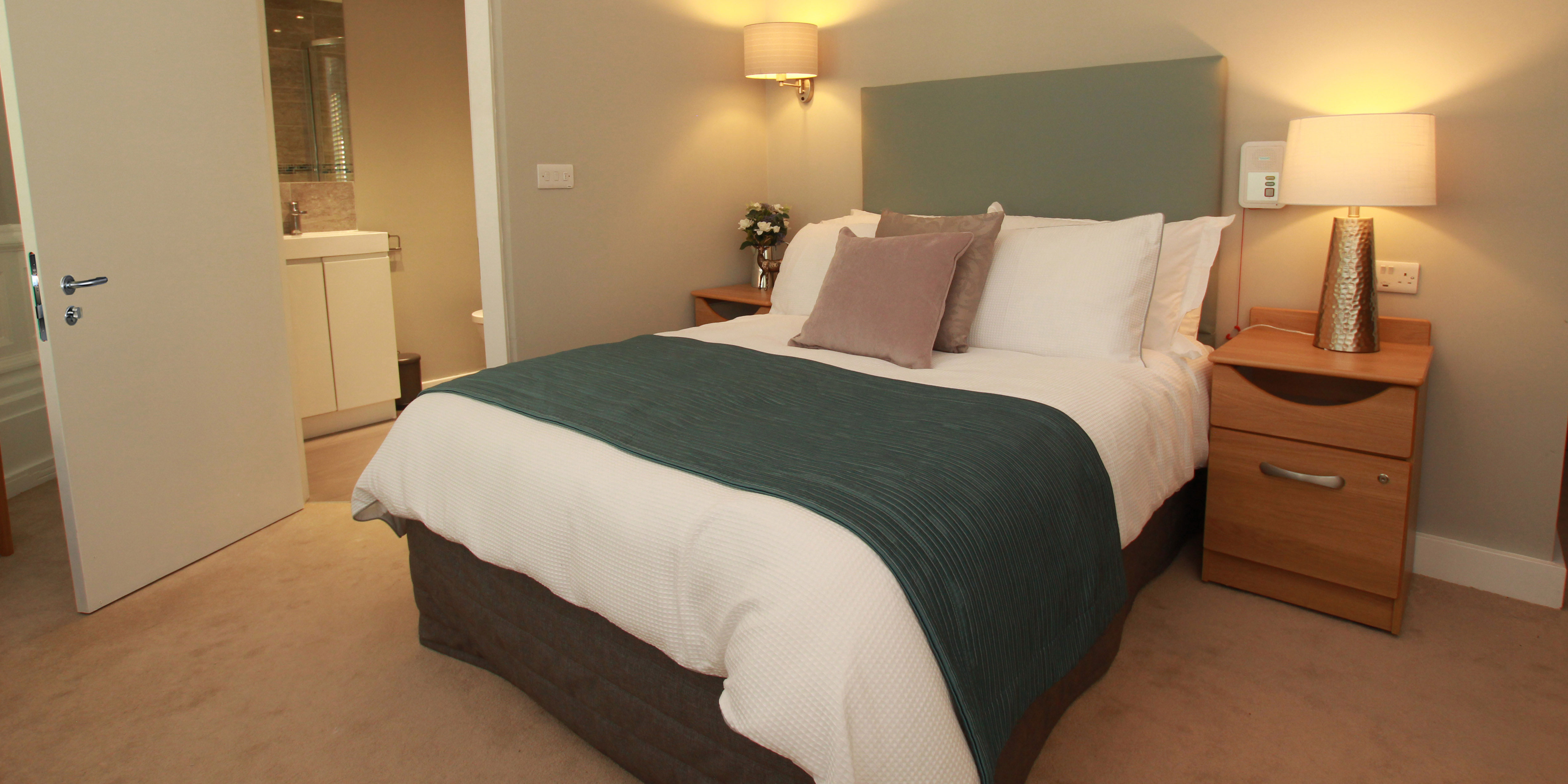 A double bed  with a bedside table next to it.