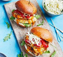 Two burgers placed on a wooden board