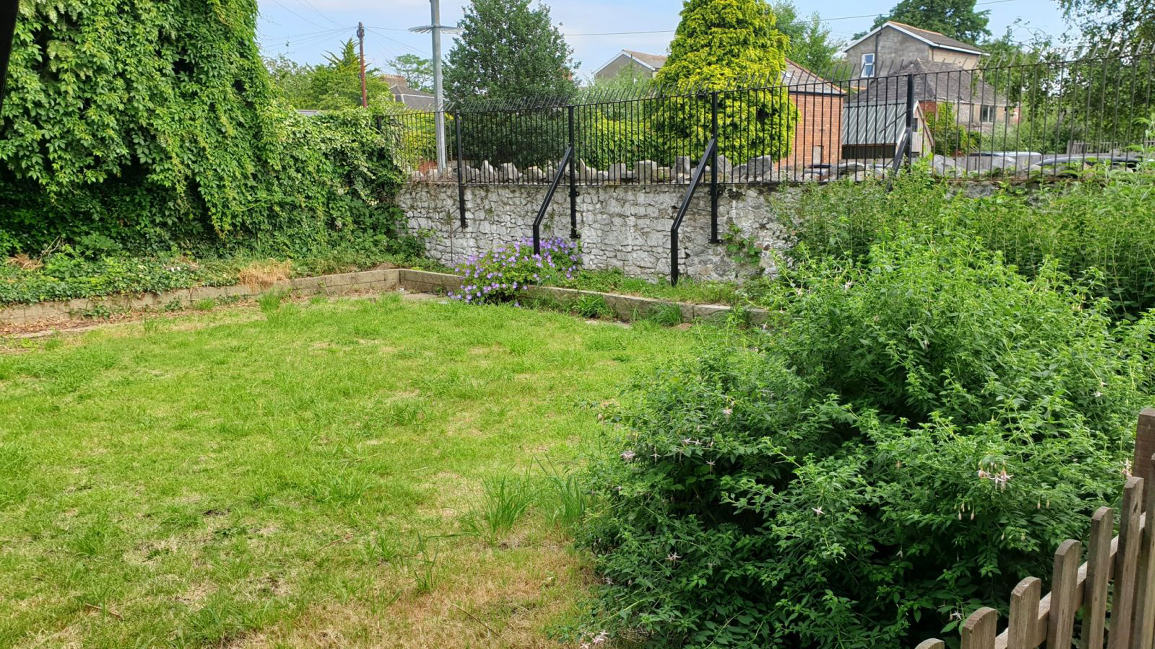 A spacious garden area with borders of flower beds