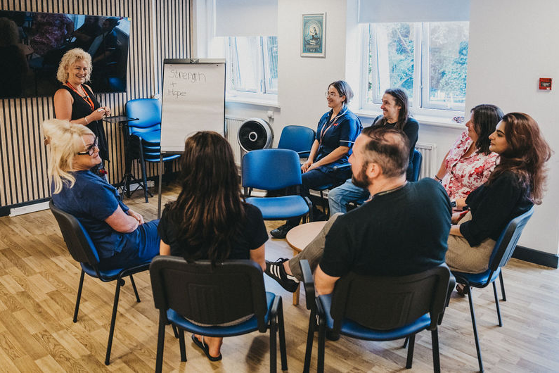 A group of people sat around in a circle having a discussion