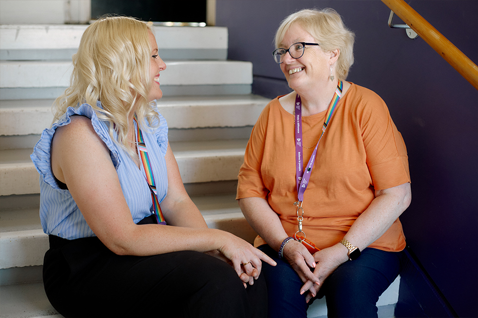 Change Grow Live colleagues sitting and chatting on a stairwell