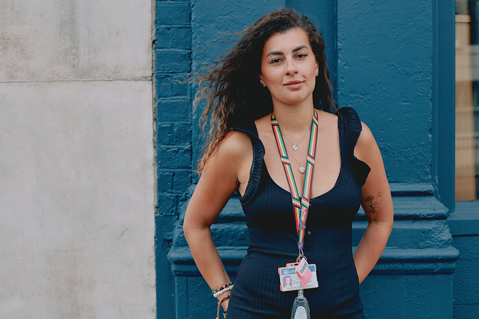 Chantel stands against a painted blue wall outside looking to the camera