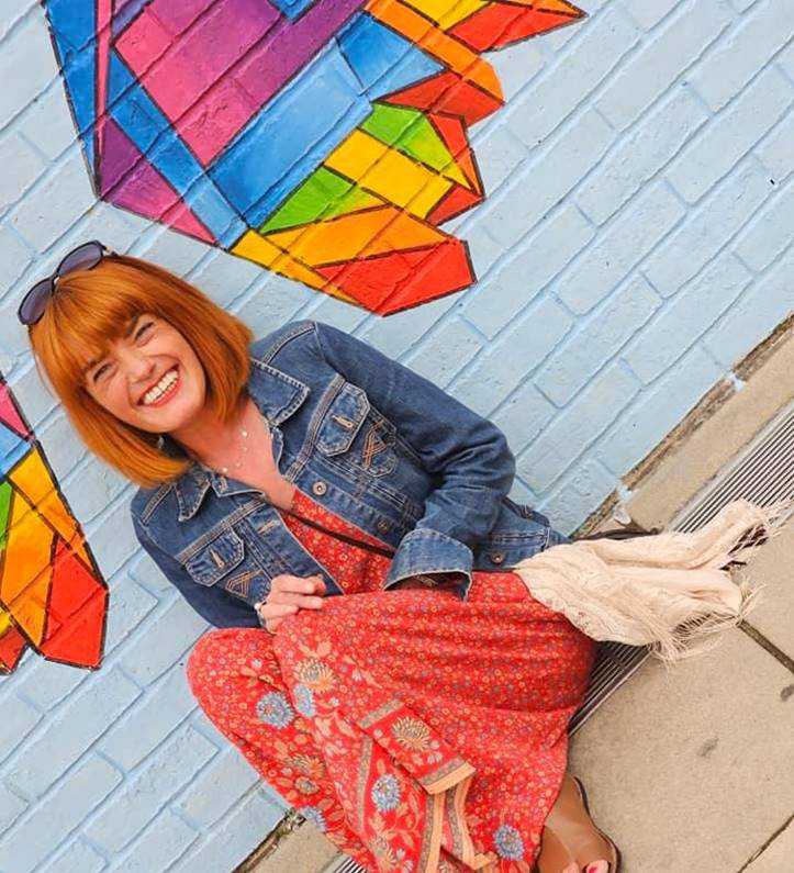 A women sat on the floor against a wall