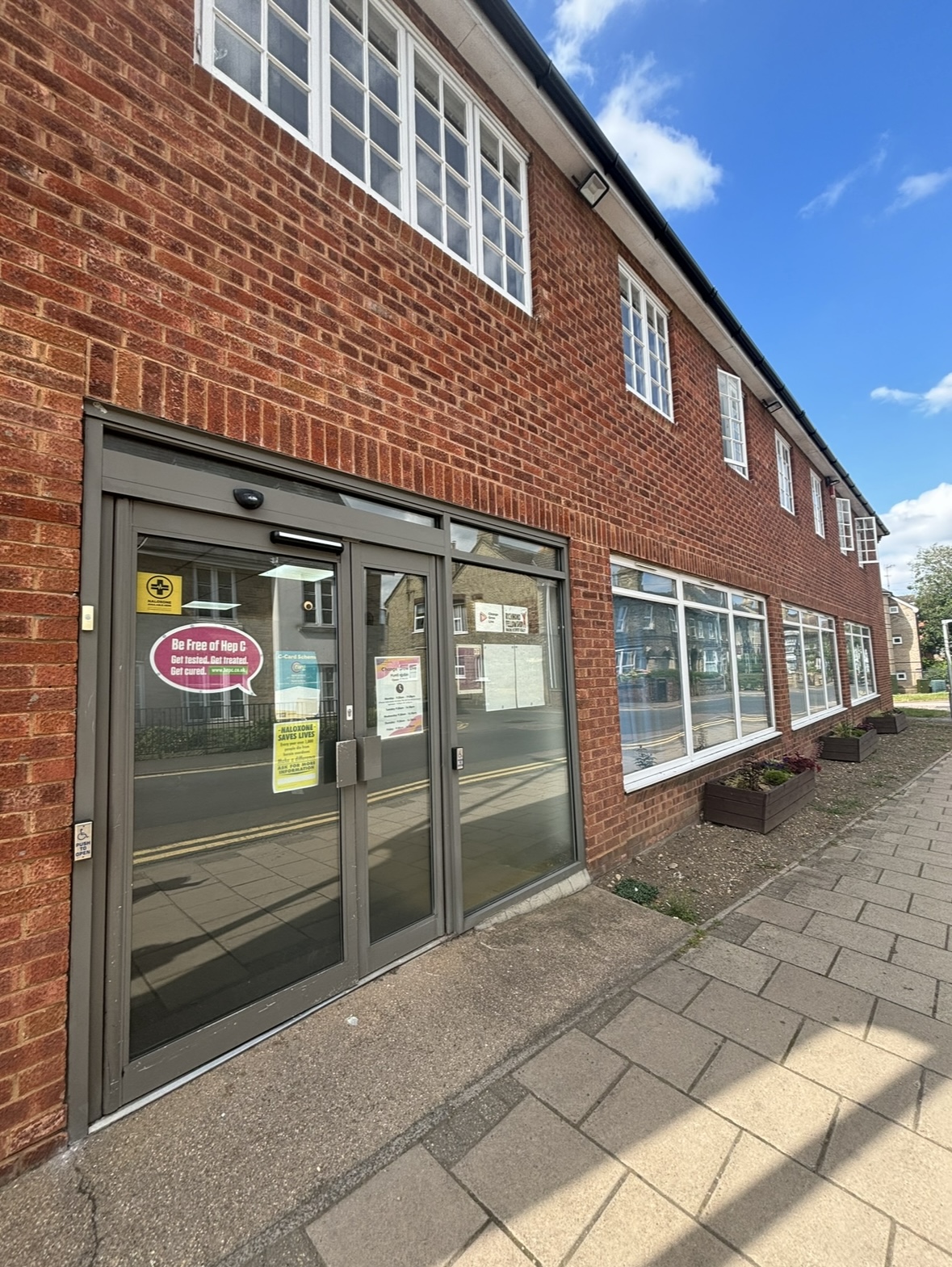 The outside of a red brick building with a big glass door