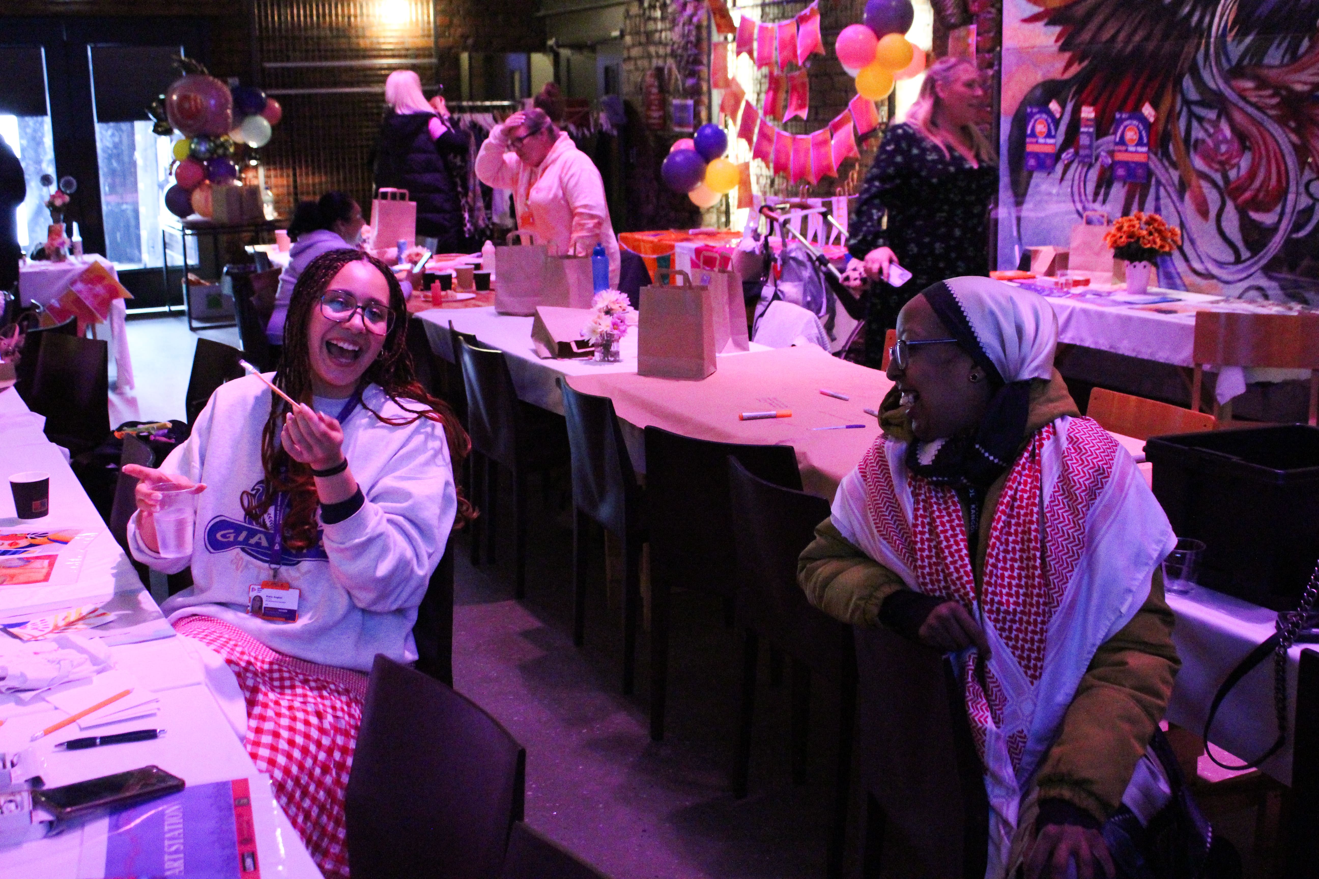 Two women sat at tables laughing