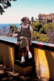 A young woman sat on a wall overlooking the countryside