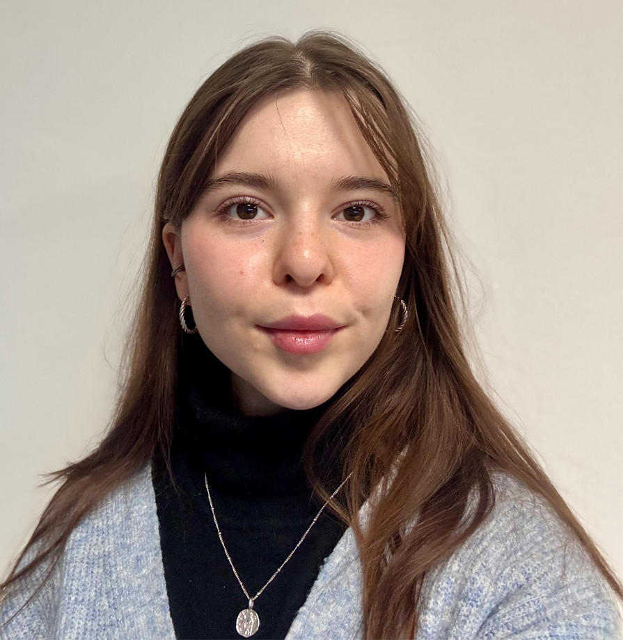 A young woman with long brown hair and a grey cardigan
