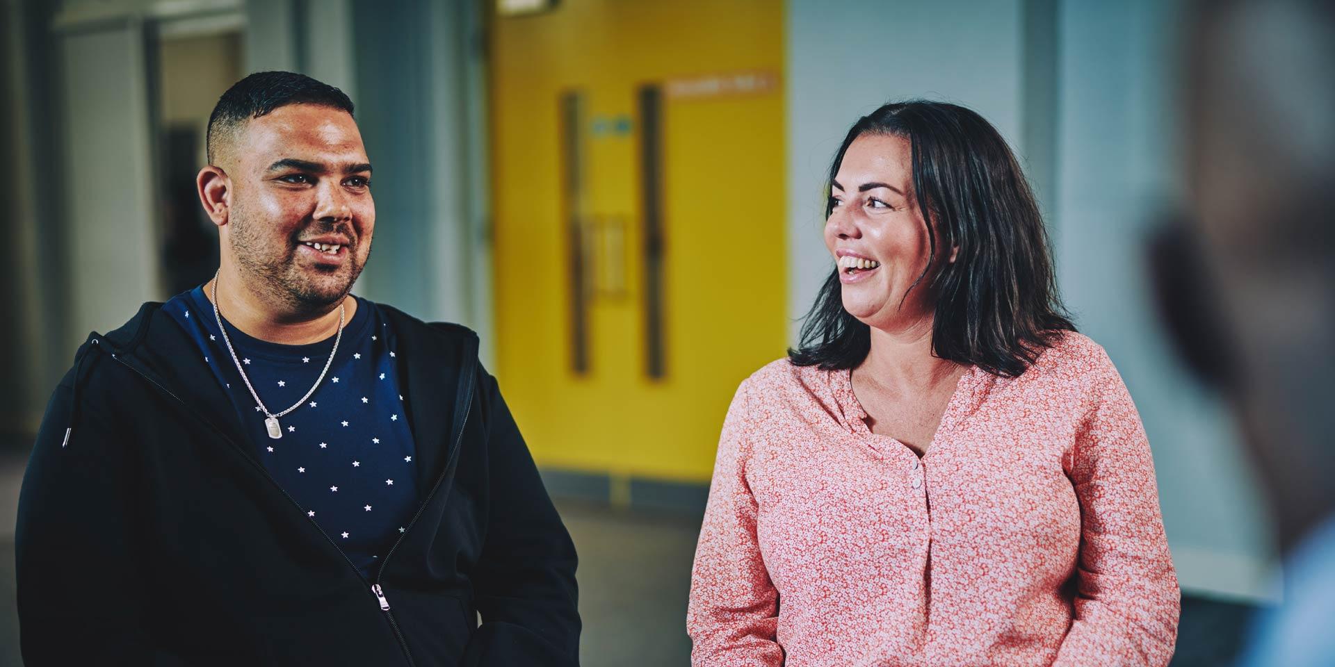 a man and a woman talking and smiling