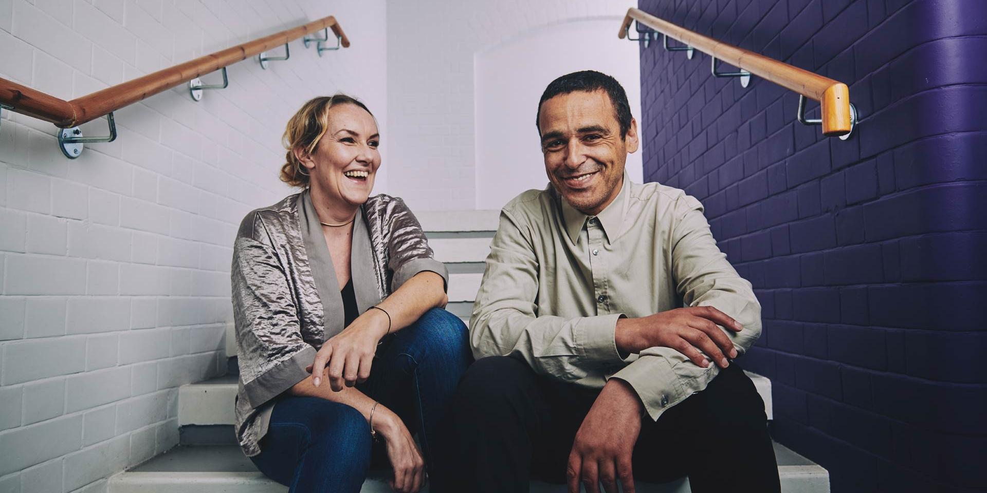a woman and a man sitting on the stairs laughing