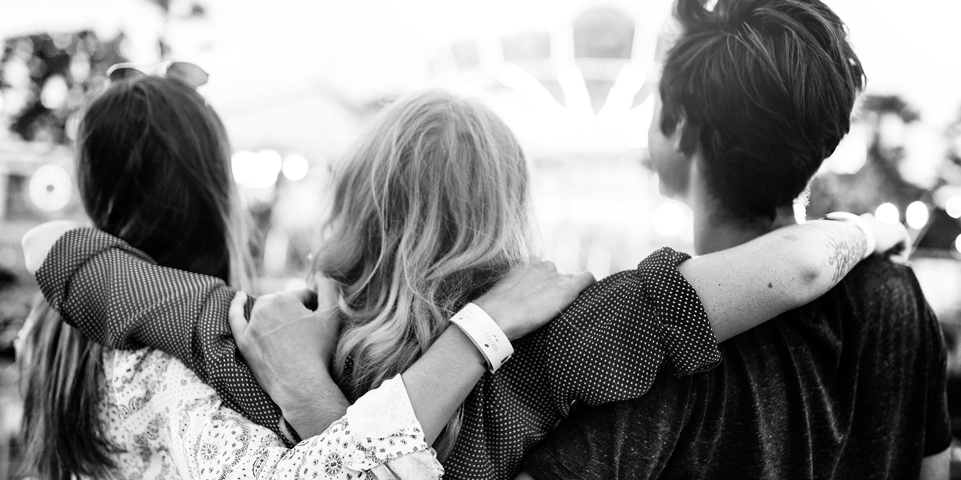 Three young people with their arms around each other