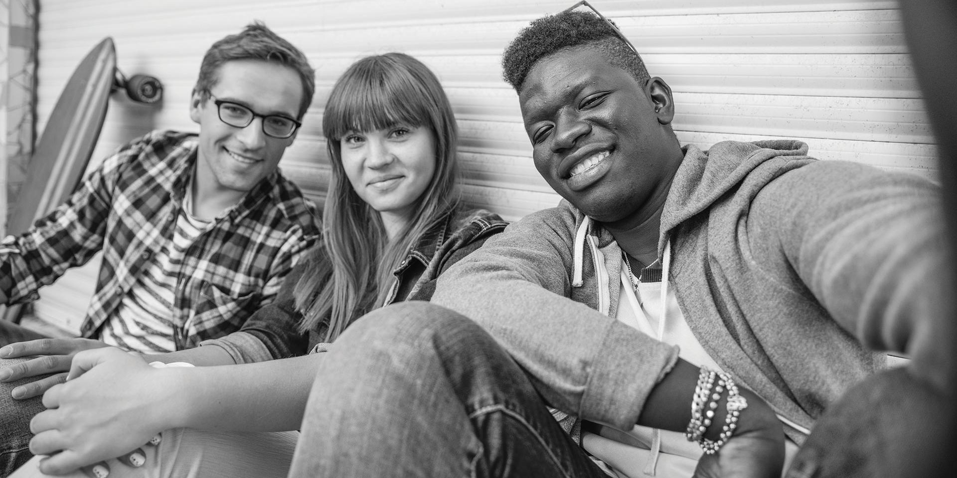 Three young people taking a group selfie