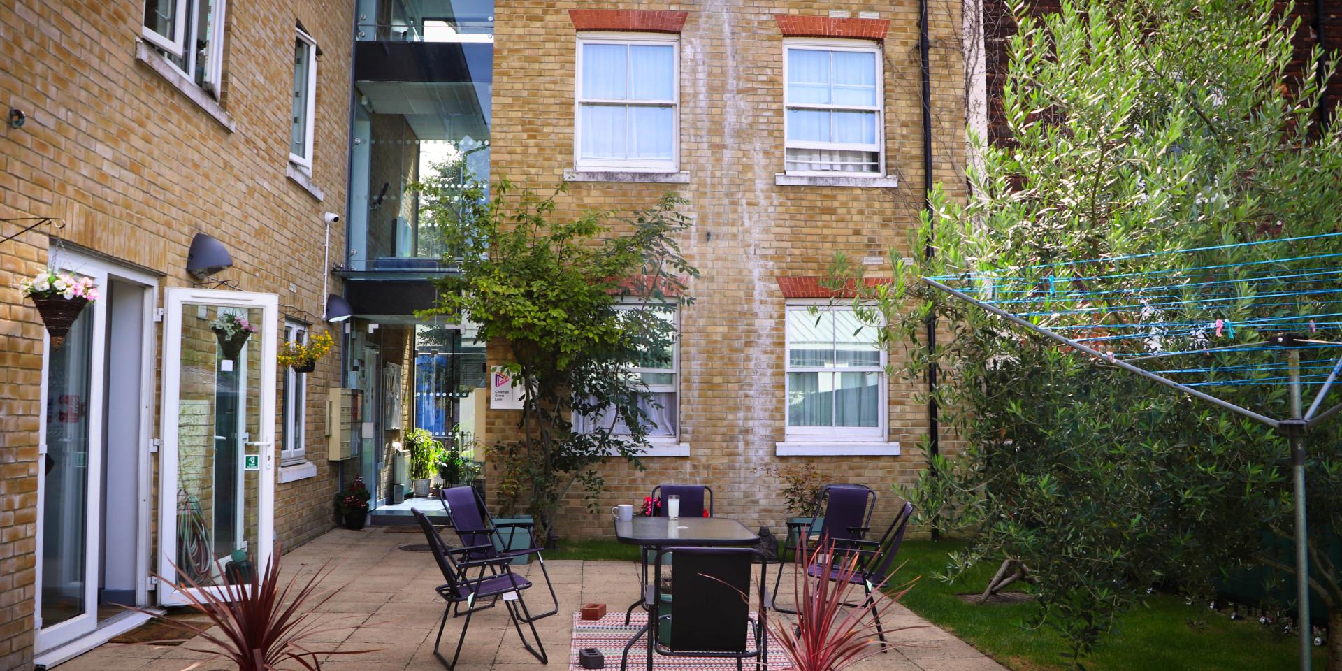 A small courtyard garden with a table and chairs 