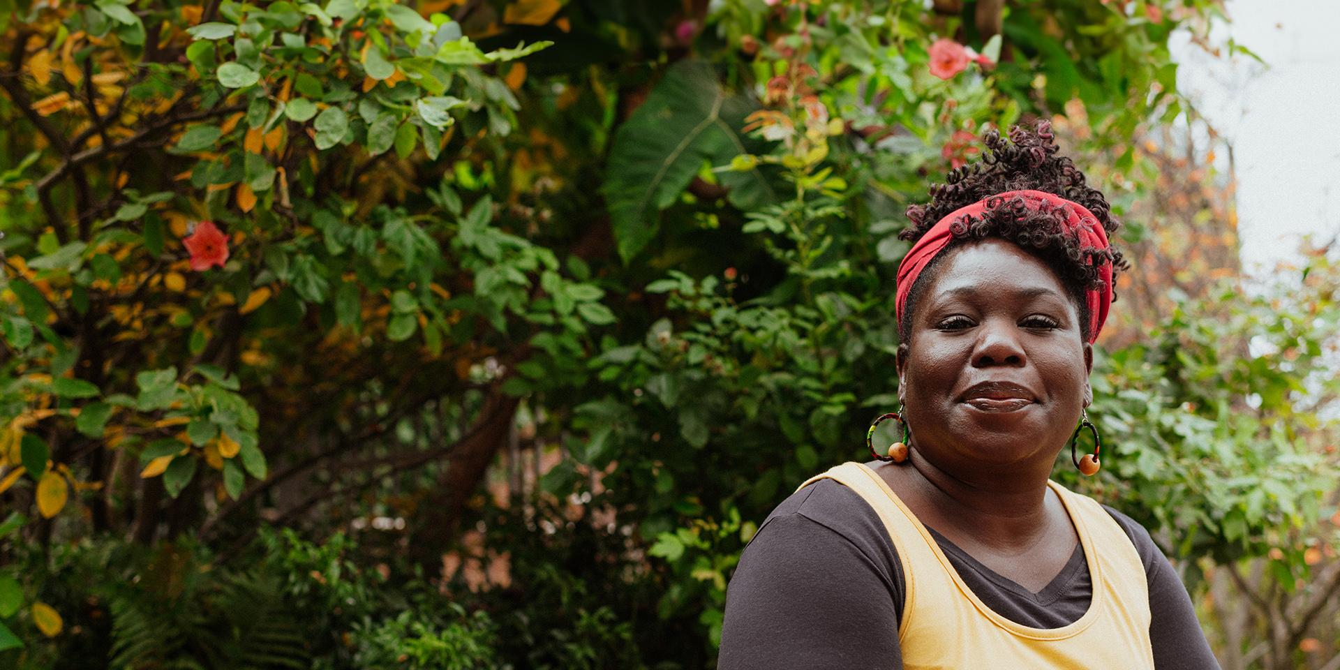 A person looking hopefully at the camera with foliage in the background