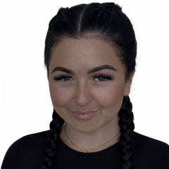 Beth has dark hair braided into two french plaits