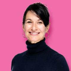 Angelene has dark hair pulled up and is wearing a black turtleneck top