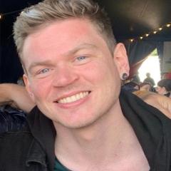 Tom has short blonde hair and has his ear pierced