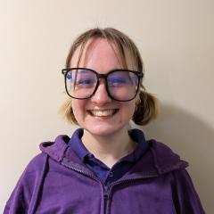 Becki has blonde hair and wears glasses