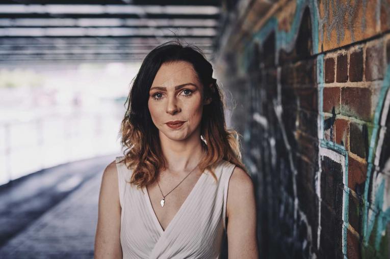 woman standing under a bridge 