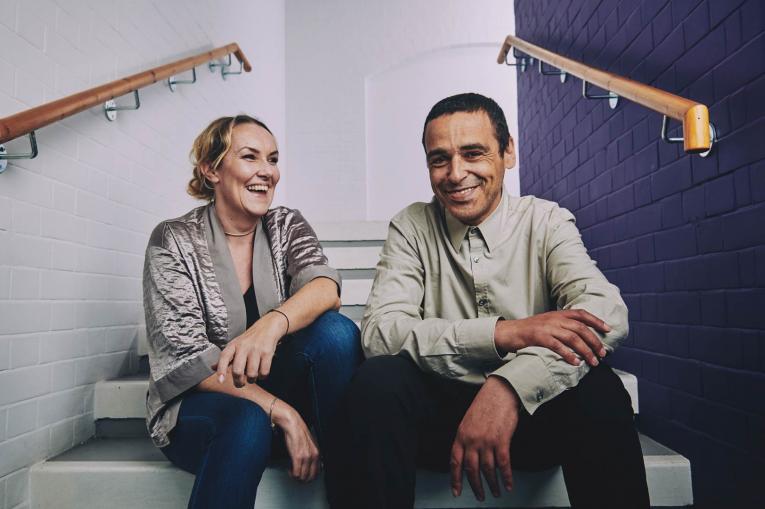 a woman and a man sitting on the stairs laughing