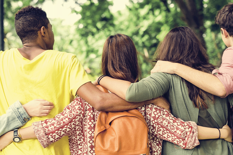 Five young people with their backs to the camera and arms around each other