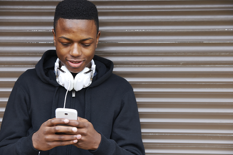 Young person looking down at phone