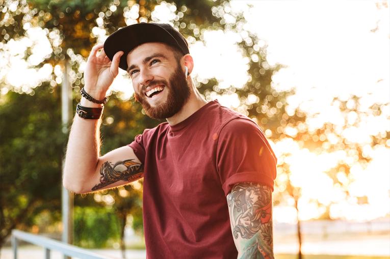 Young man with tattoos smiling broadly