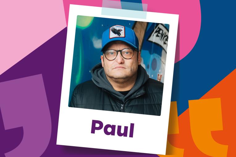 Colourful background made up of overside quotation marks. In the centre is a polaroid photo of a man wearing a dark hoodie and a blue baseball cap. The name Paul is on the bottom of the polaroid.