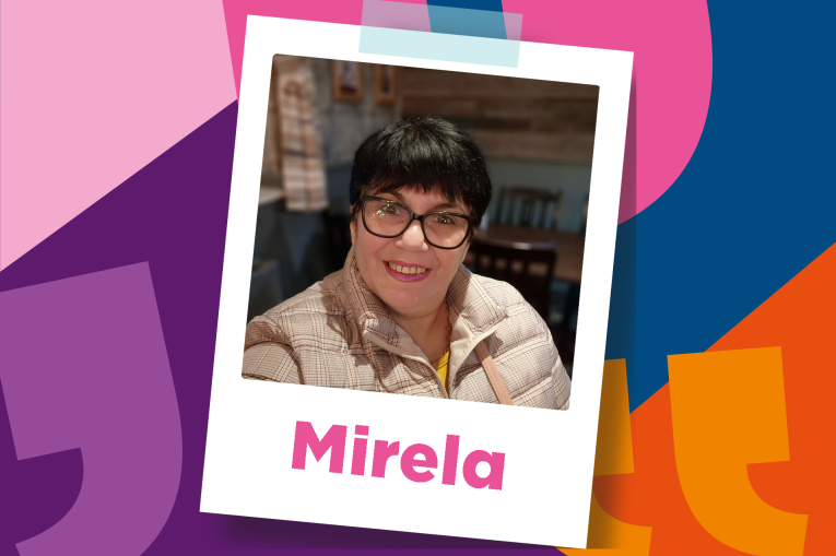 Mirela has a short black pixie cut and wears glasses