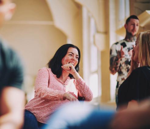 lady sitting on a chair talking to someone and laughing