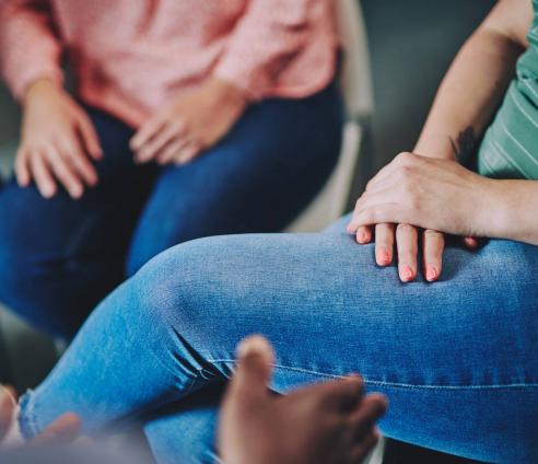 two women sitting - a photo of only their hands on their jeans