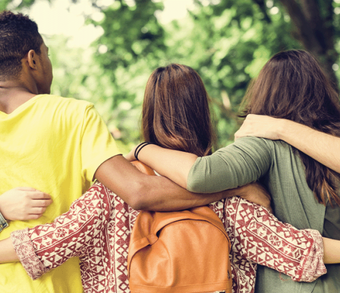 Five young people with their backs to the camera and arms around each other