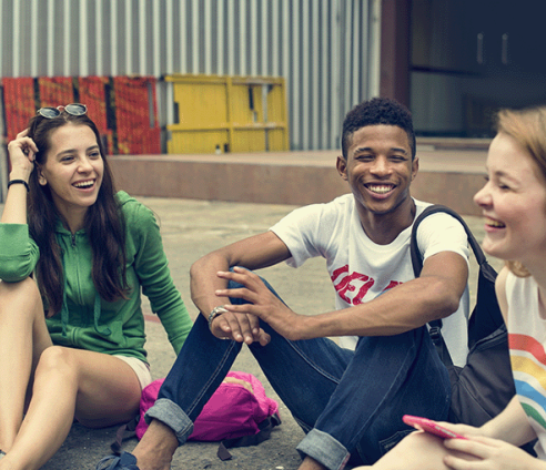 Three young people outside talking and laughing