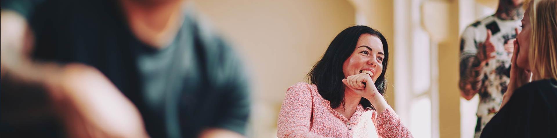 lady sitting on a chair talking to someone and laughing