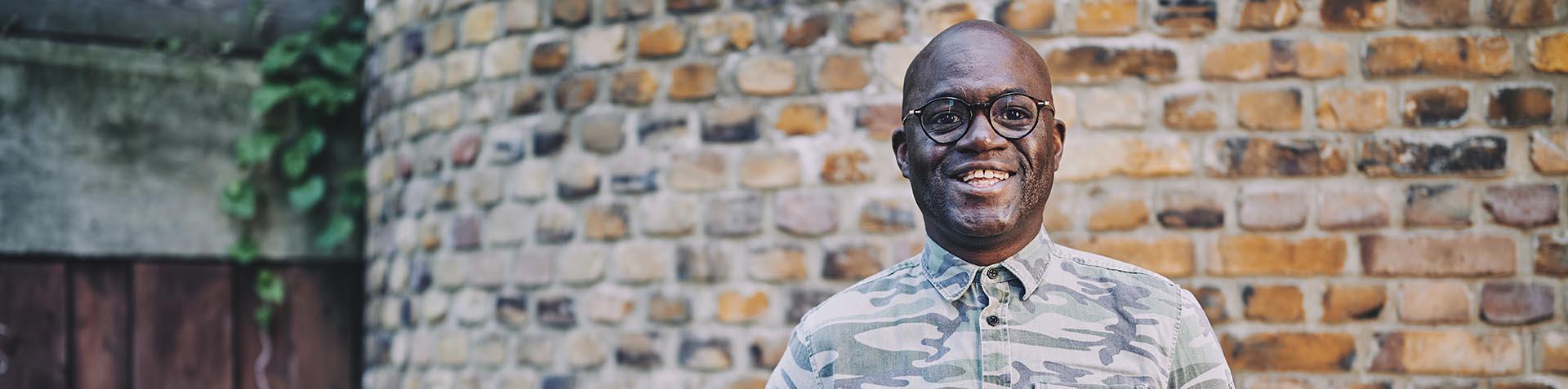 man smiling in front of a wall