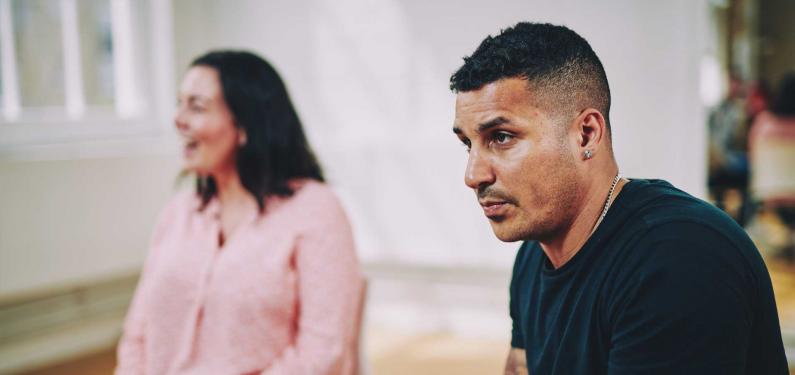 A man and a woman are sitting having a conversation