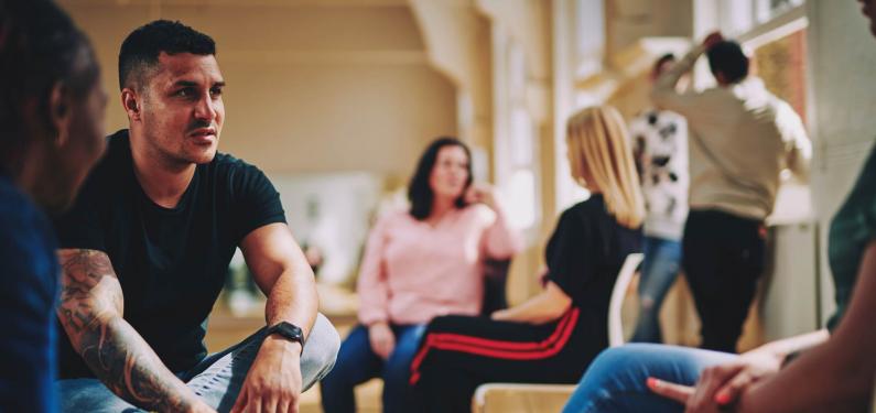 A group of people are sitting having a conversation 