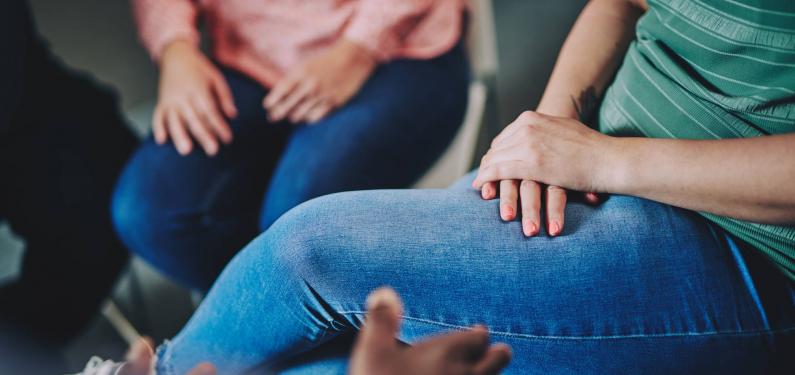 two women sitting - a photo of only their hands on their jeans
