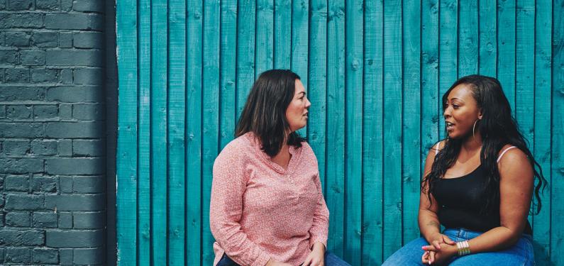 Two women are sitting outside having a conversation