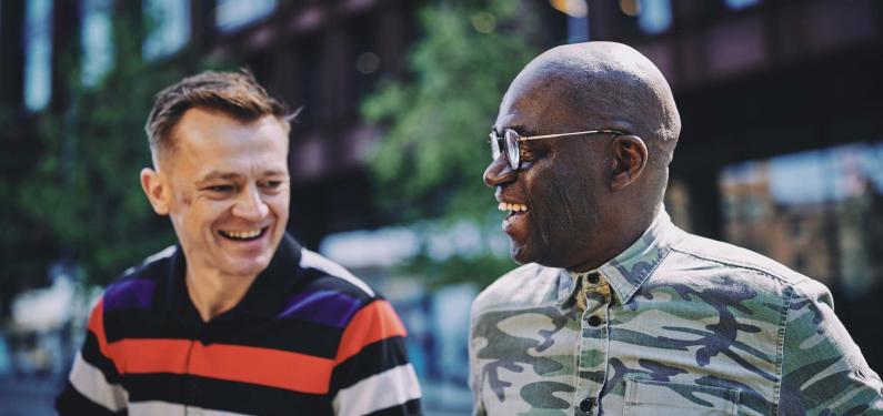 two men talking and smiling