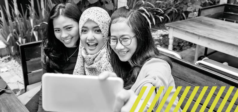 Three young people taking a group selfie