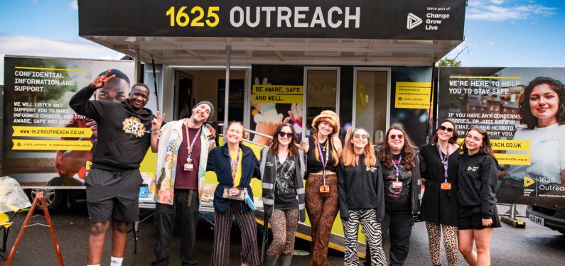 A group of people stood in front of a van