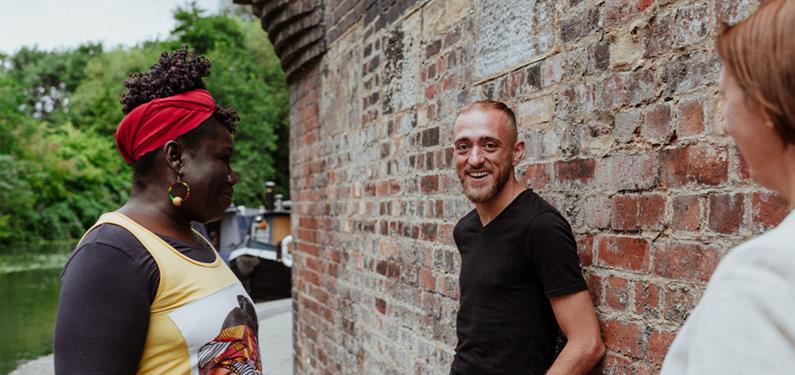 Three people talking with one looking and smiling at the camera