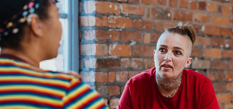 Two people in conversation with one slightly out of focus